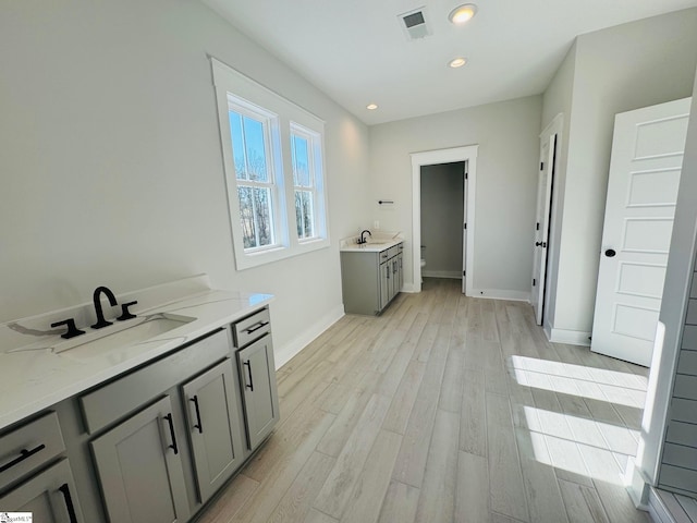 bathroom featuring wood-type flooring, vanity, and toilet