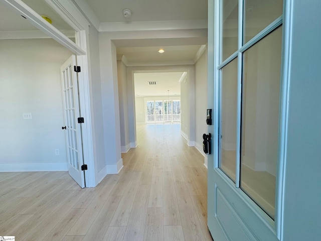 hallway featuring crown molding, french doors, and light wood-type flooring