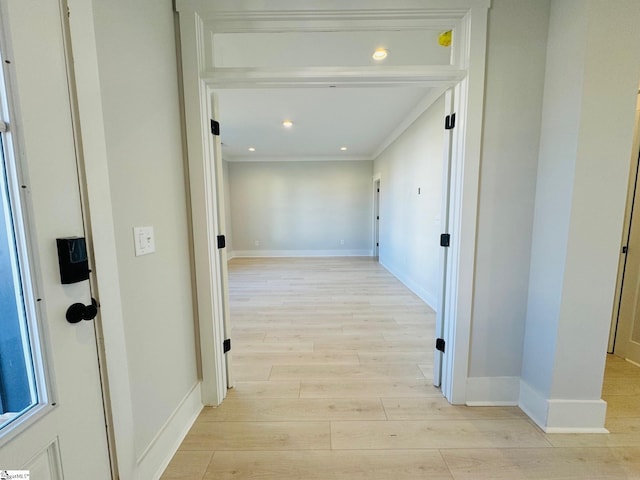 corridor featuring crown molding and light hardwood / wood-style flooring