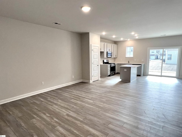 kitchen featuring a breakfast bar area, a kitchen island, stainless steel appliances, and hardwood / wood-style flooring