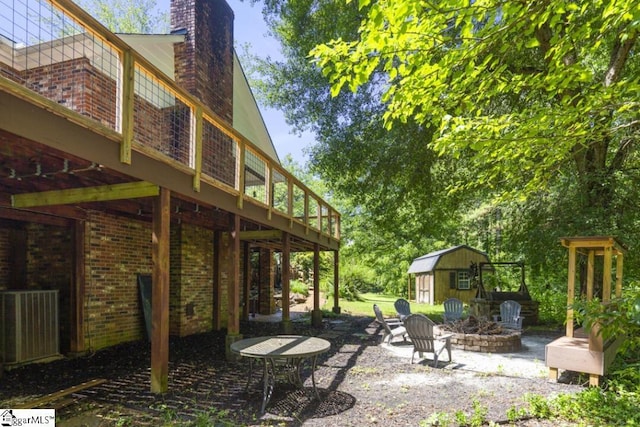 view of yard with a storage shed, an outdoor fire pit, and a patio