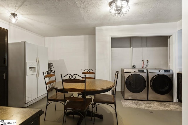 dining space featuring separate washer and dryer, concrete floors, and a textured ceiling