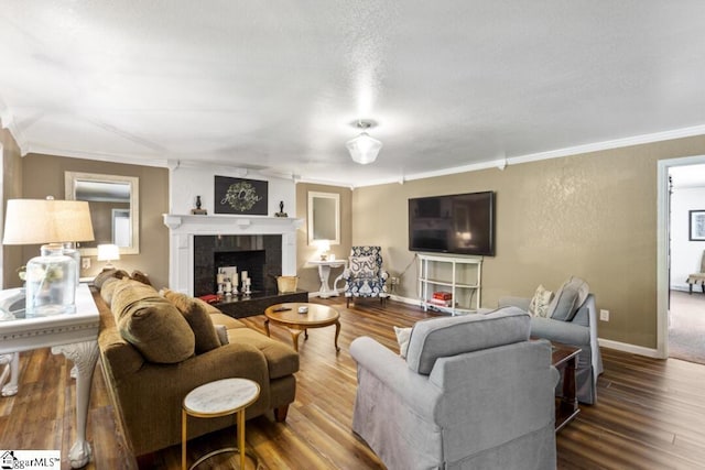 living room featuring hardwood / wood-style floors, a textured ceiling, and ornamental molding