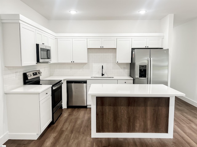 kitchen featuring white cabinets, a kitchen island, sink, and appliances with stainless steel finishes