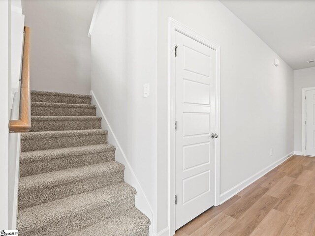 stairway featuring baseboards and wood finished floors