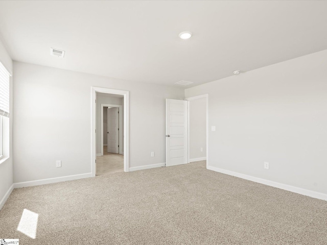 unfurnished bedroom featuring baseboards, visible vents, and light colored carpet