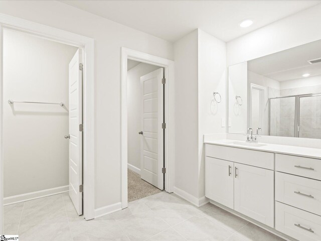 full bath featuring a stall shower, tile patterned flooring, vanity, and baseboards