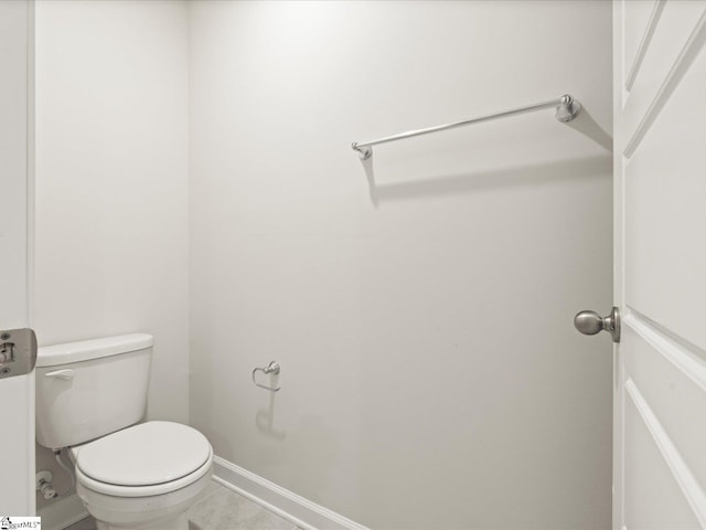 bathroom with toilet and baseboards