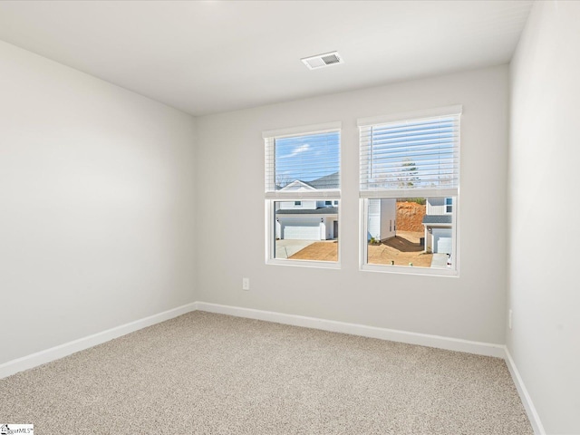 carpeted empty room featuring visible vents and baseboards