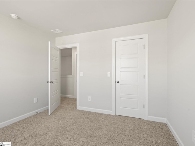 unfurnished bedroom with baseboards and light colored carpet