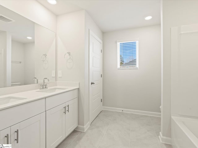 bathroom with visible vents, a sink, toilet, and double vanity