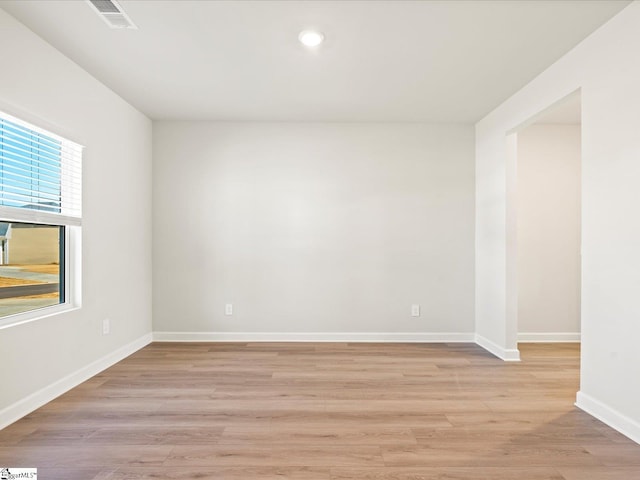 unfurnished room with light wood finished floors, recessed lighting, visible vents, and baseboards