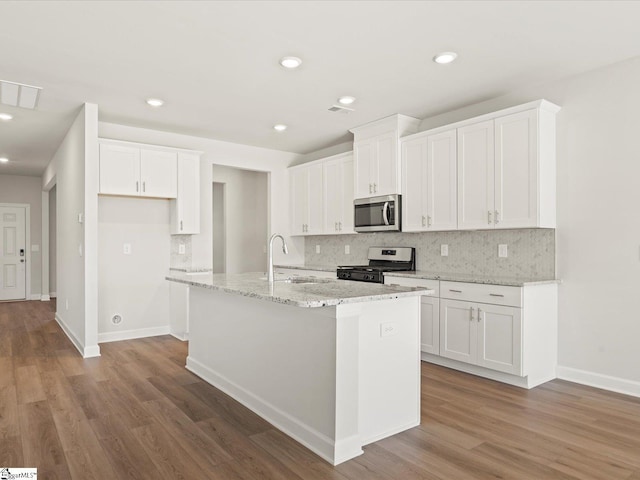 kitchen with stainless steel appliances, a kitchen island with sink, white cabinetry, and a sink