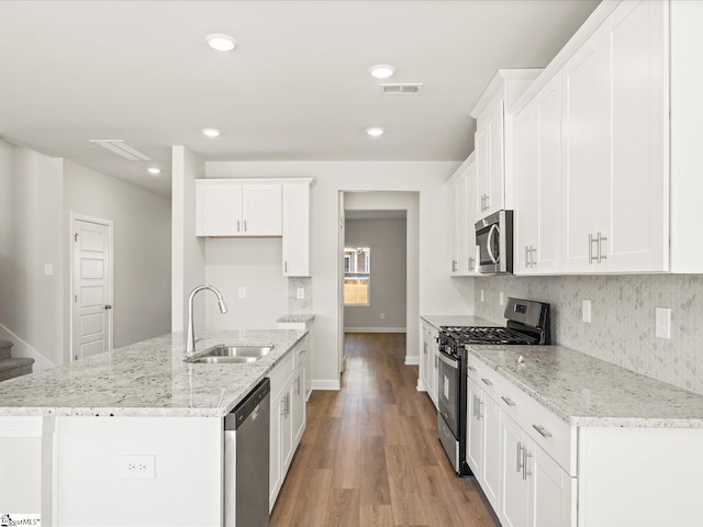 kitchen with light wood-style flooring, a sink, visible vents, appliances with stainless steel finishes, and backsplash