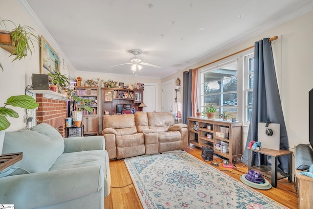 living room featuring a brick fireplace, ceiling fan, ornamental molding, and light hardwood / wood-style flooring