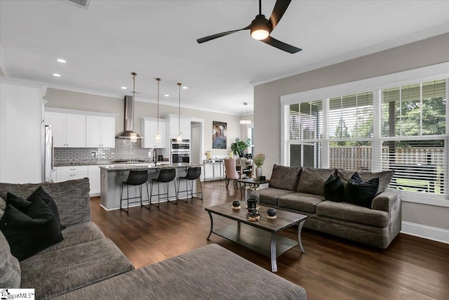 living room featuring crown molding, sink, ceiling fan, and dark hardwood / wood-style floors