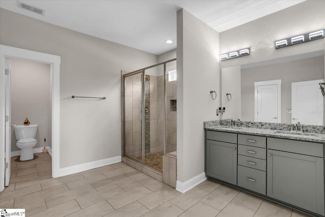 bathroom with walk in shower, vanity, and toilet