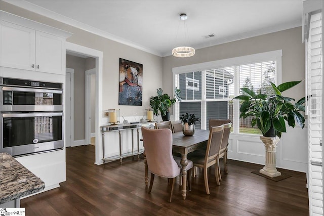 dining space with a chandelier, dark hardwood / wood-style floors, and ornamental molding