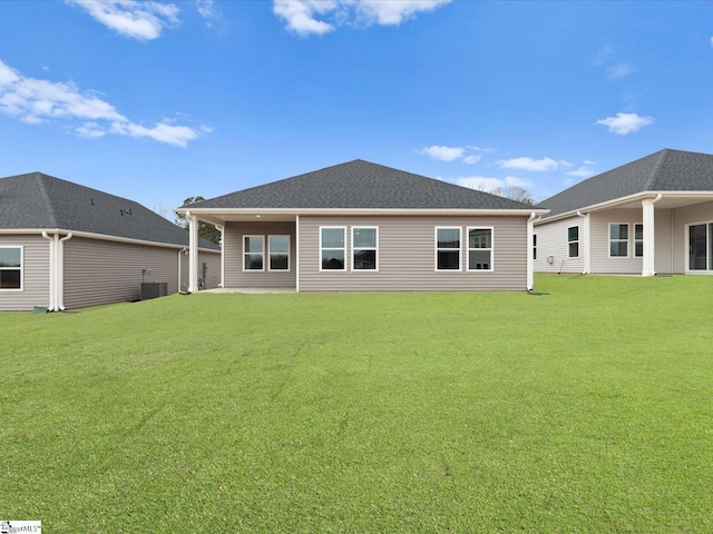 rear view of property featuring central AC unit and a yard