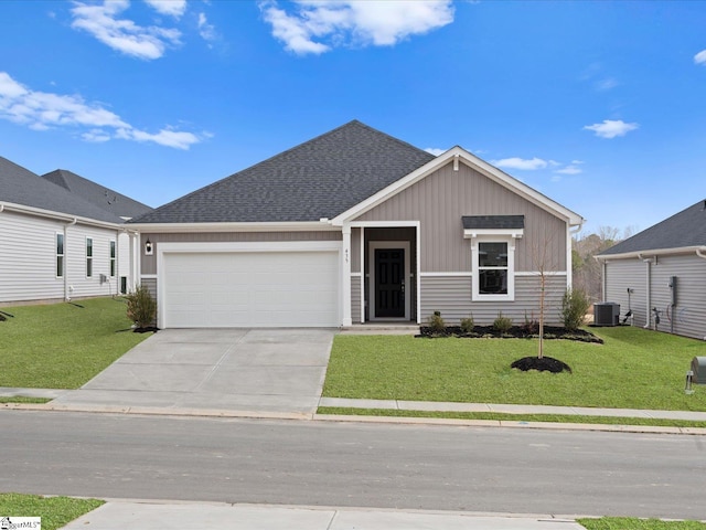 view of front facade with a garage, a front lawn, and central air condition unit