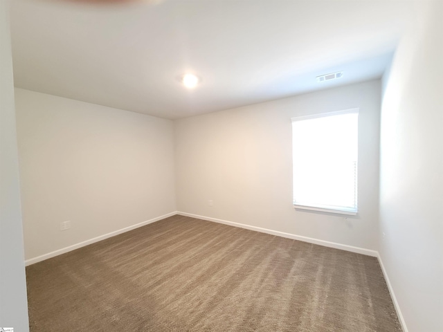 unfurnished room with dark colored carpet