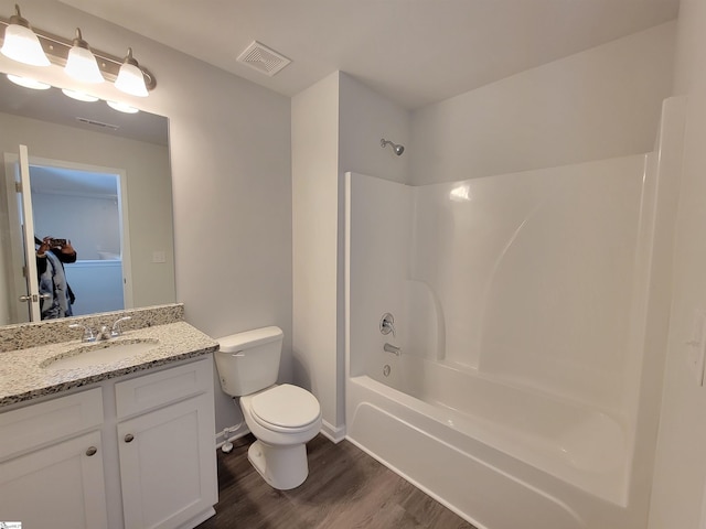 full bathroom featuring bathing tub / shower combination, hardwood / wood-style floors, vanity, and toilet