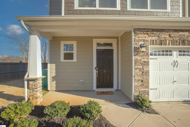 property entrance featuring covered porch and a garage