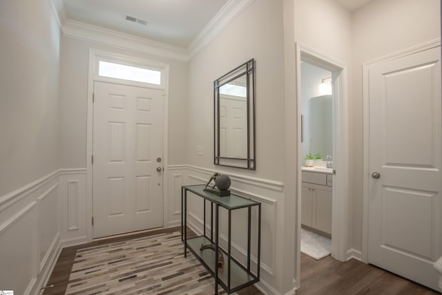 foyer entrance featuring hardwood / wood-style flooring and ornamental molding