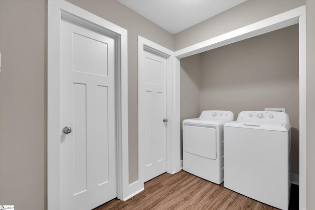 washroom featuring washer and dryer and light hardwood / wood-style flooring