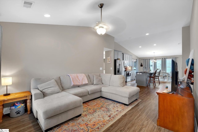 living room with lofted ceiling, ceiling fan, wood-type flooring, and sink