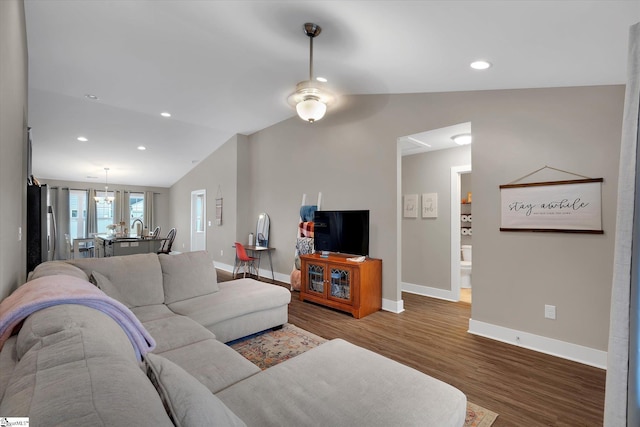 living room featuring hardwood / wood-style flooring, ceiling fan, and lofted ceiling