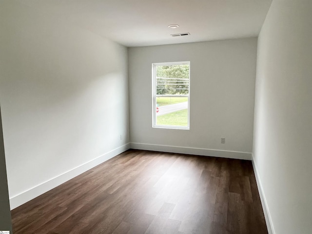 empty room with dark hardwood / wood-style flooring