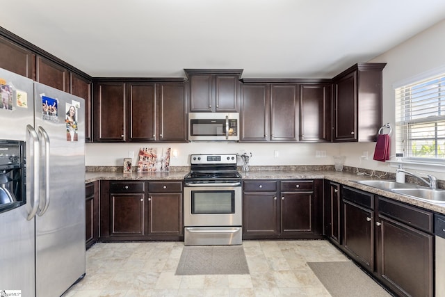 kitchen featuring appliances with stainless steel finishes, dark brown cabinetry, and sink