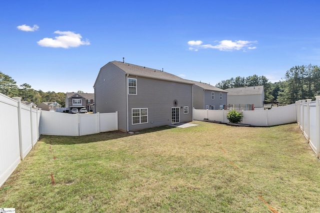 rear view of house featuring a lawn