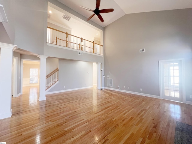 unfurnished living room with decorative columns, ceiling fan, light hardwood / wood-style flooring, and high vaulted ceiling