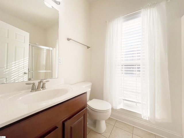 bathroom featuring tile patterned floors, vanity, toilet, and walk in shower