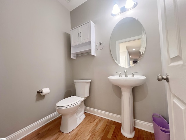 bathroom with hardwood / wood-style flooring and toilet