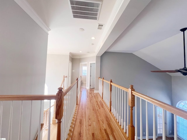 corridor featuring crown molding, light hardwood / wood-style flooring, and vaulted ceiling