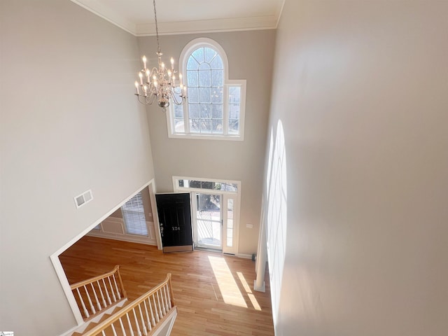 foyer with a wealth of natural light, a towering ceiling, and an inviting chandelier