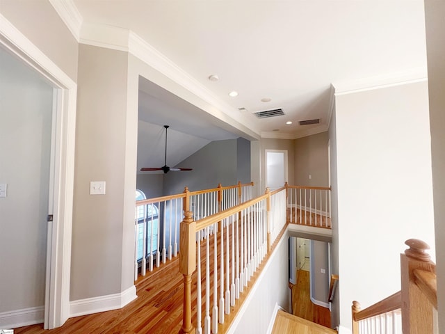 corridor featuring hardwood / wood-style flooring, crown molding, and lofted ceiling