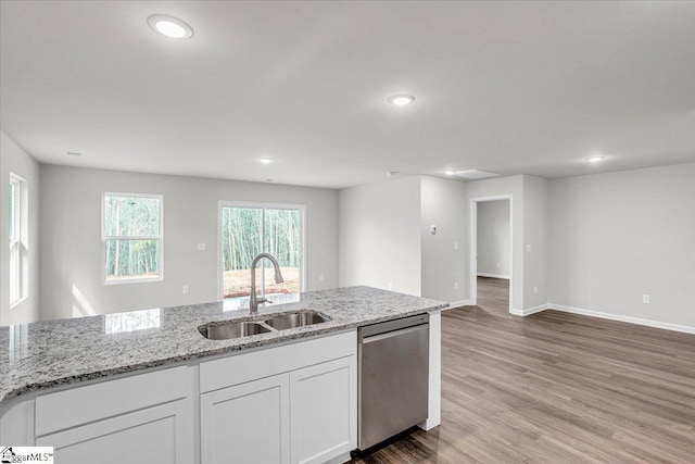 kitchen featuring stainless steel dishwasher, light stone countertops, sink, and white cabinets