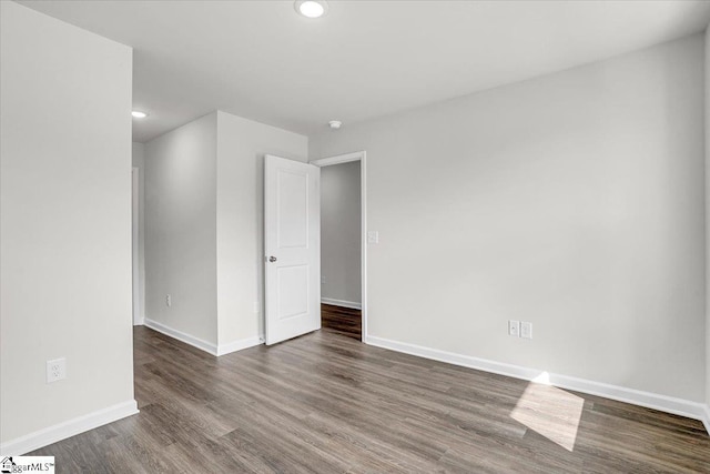 empty room with dark hardwood / wood-style flooring