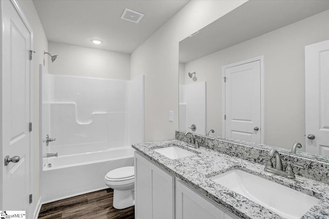 full bathroom with vanity, toilet, shower / bath combination, and hardwood / wood-style floors