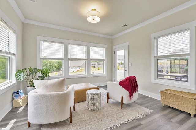 sitting room featuring wood-type flooring and crown molding