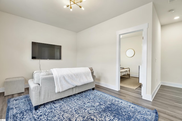 bedroom featuring hardwood / wood-style flooring, a notable chandelier, and connected bathroom