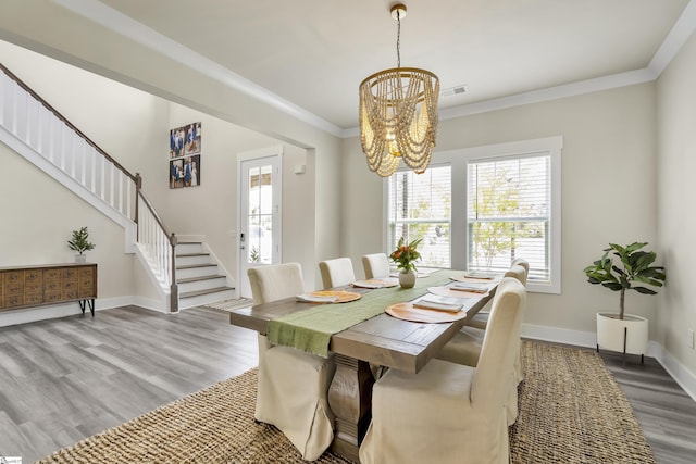 dining area featuring a chandelier, wood-type flooring, and ornamental molding