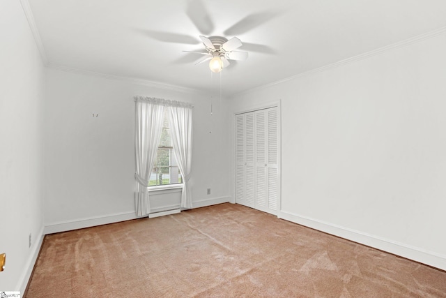 carpeted empty room featuring ceiling fan and ornamental molding