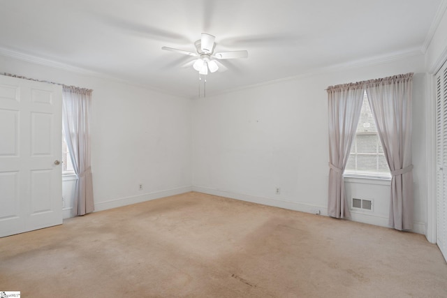 carpeted spare room featuring ceiling fan and crown molding