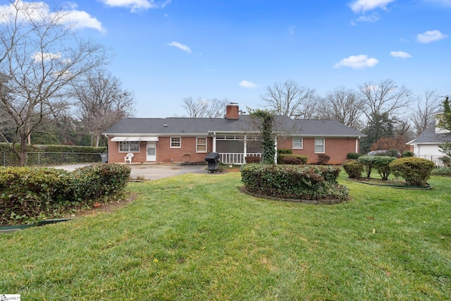 rear view of property with a yard and a patio