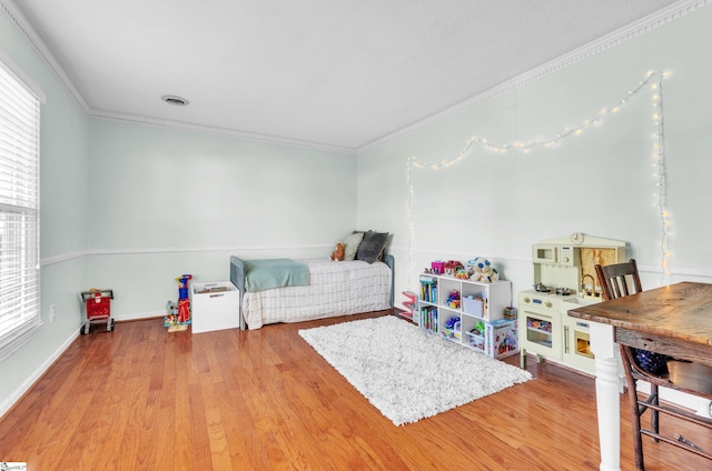 bedroom featuring light hardwood / wood-style flooring and ornamental molding